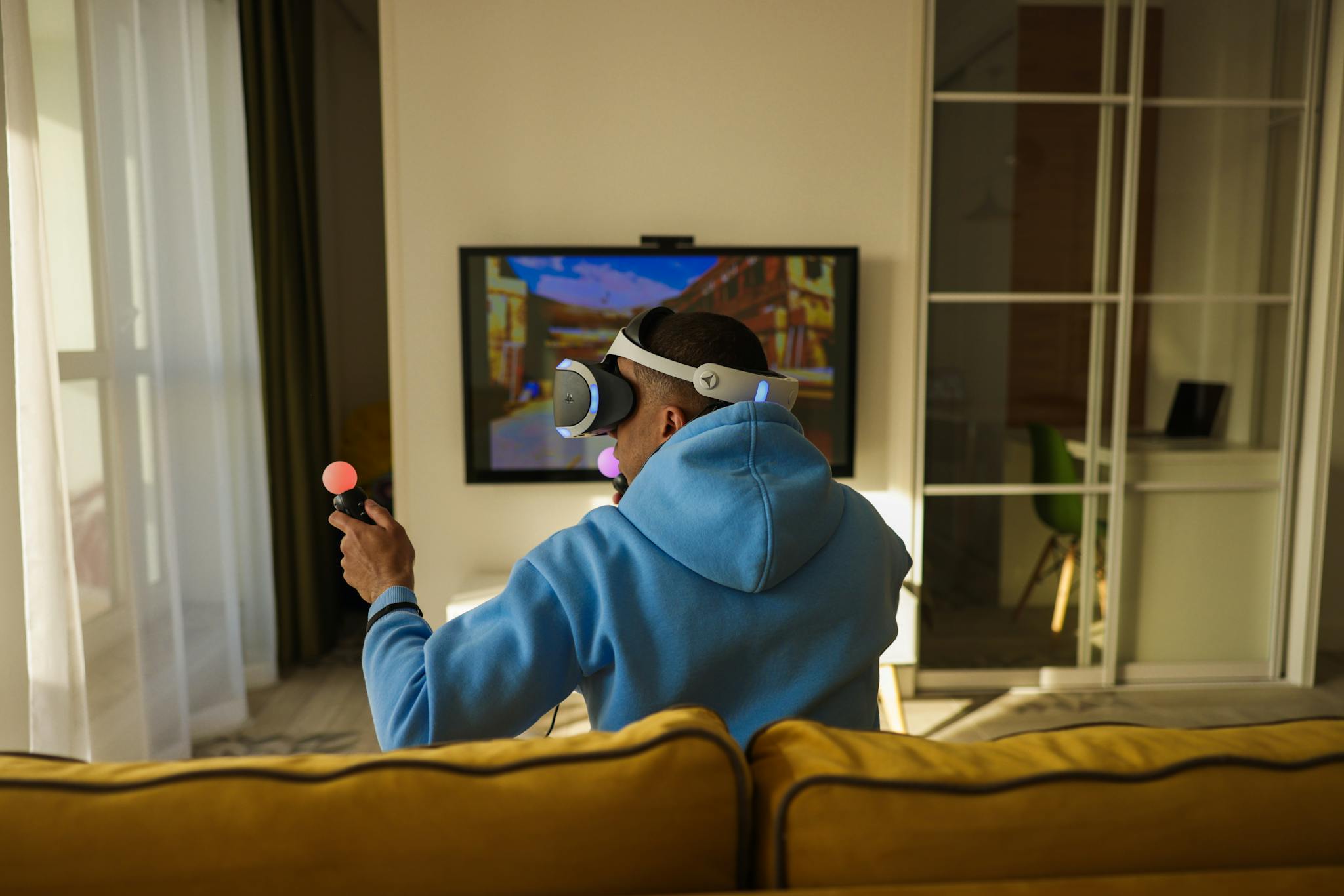 Experience immersive virtual reality gaming with headphones and controllers in a cozy living room setting.